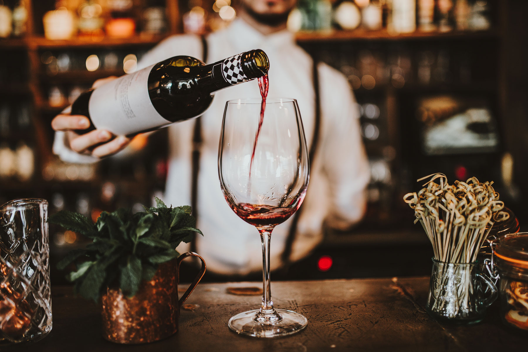 The French Quarter - Bartender pouring glass of red wine