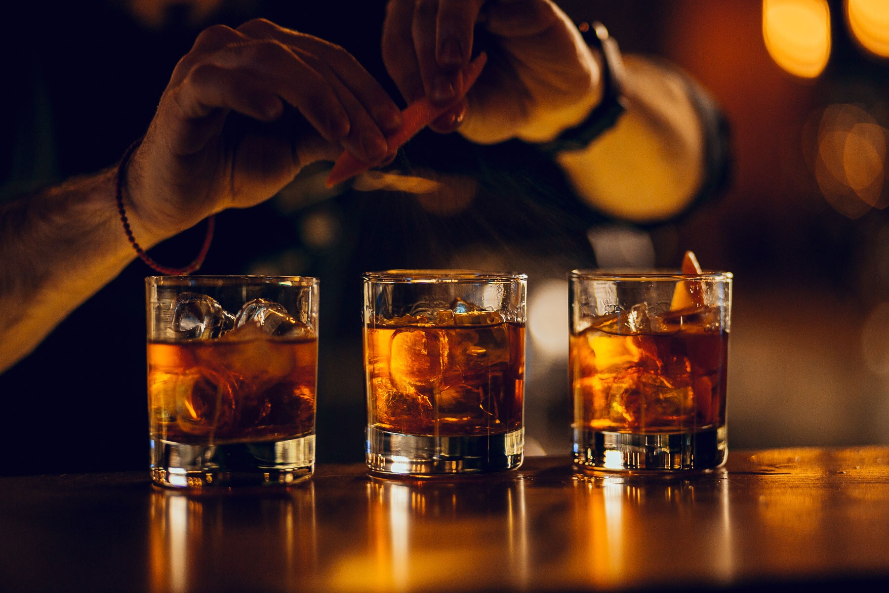 Bourbon Bar - Bartender putting the finishing touches on three bourbon drinks