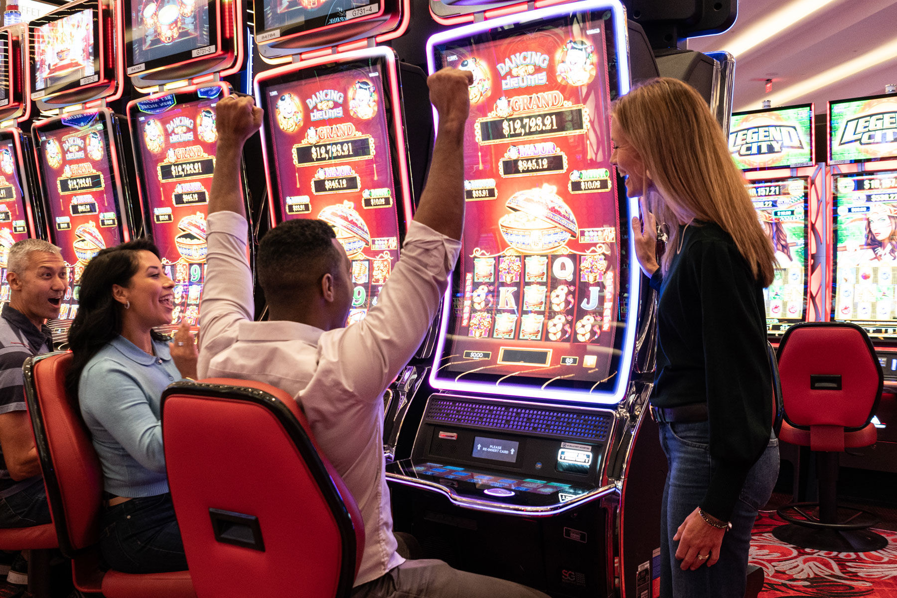 Winners - Gentleman with friends, celebrating a big win on one of the many slot machines