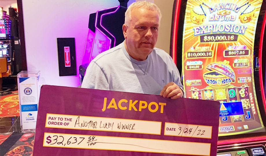 Winners - Jackpot winner with check for $32,637.54